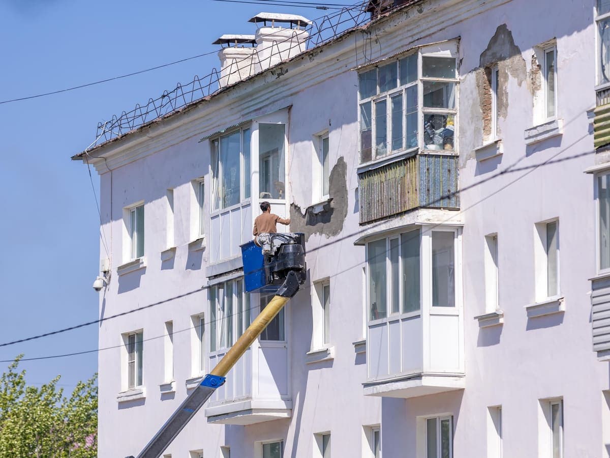 Immeuble en cours de ravalement, façadier sur nacelle